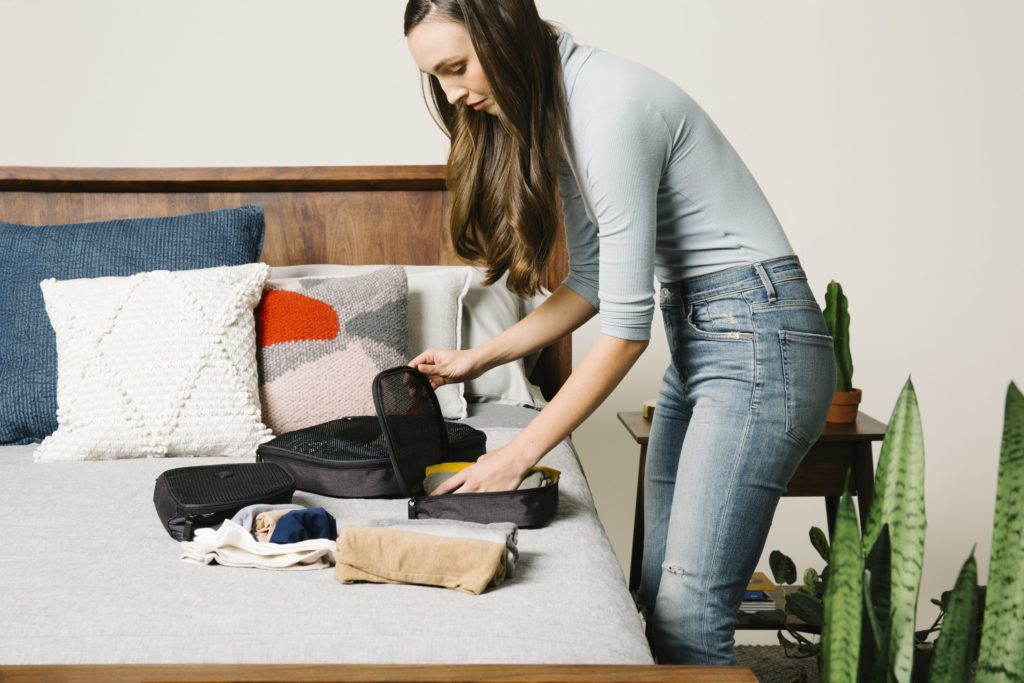 Woman packing cubes on a bed