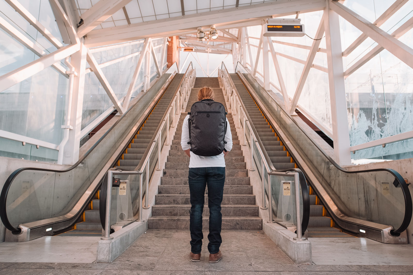 Man standing at the bottom of the stairs at SLC airport