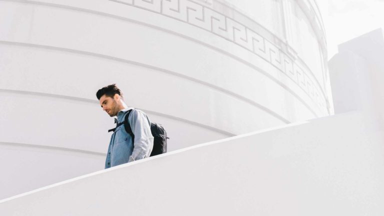 Man walking down stairs wearing backpack