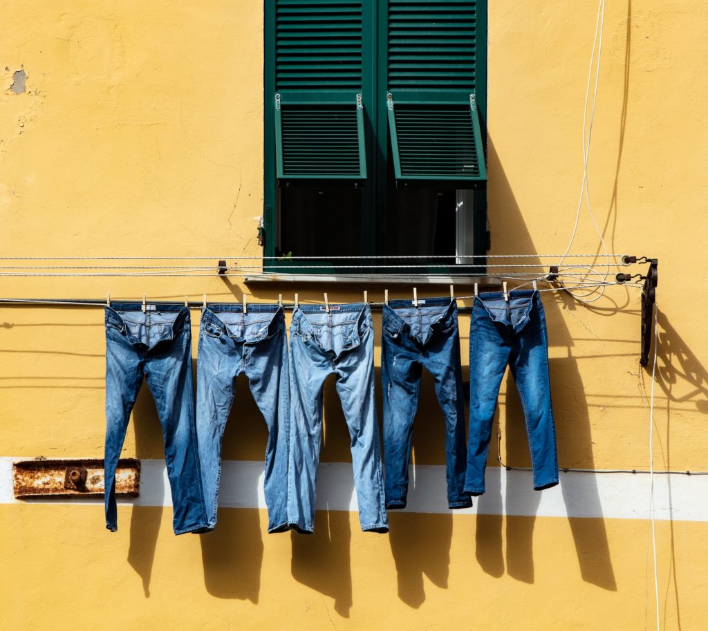 line drying jeans against yellow wall