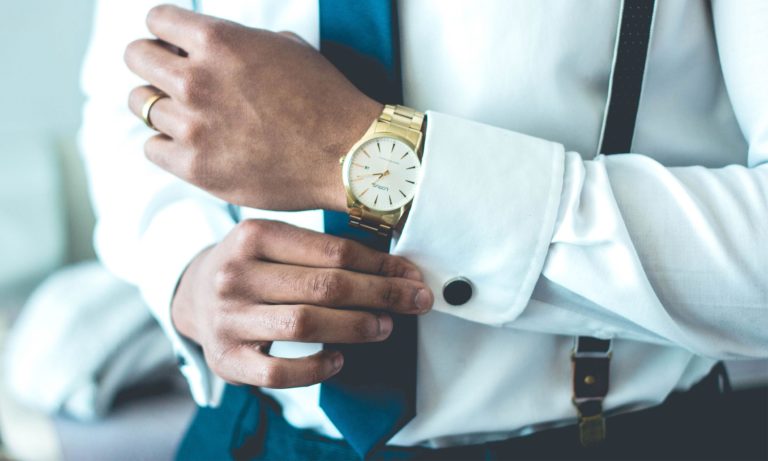 A man feels the crisp cuff of his dress shirt.