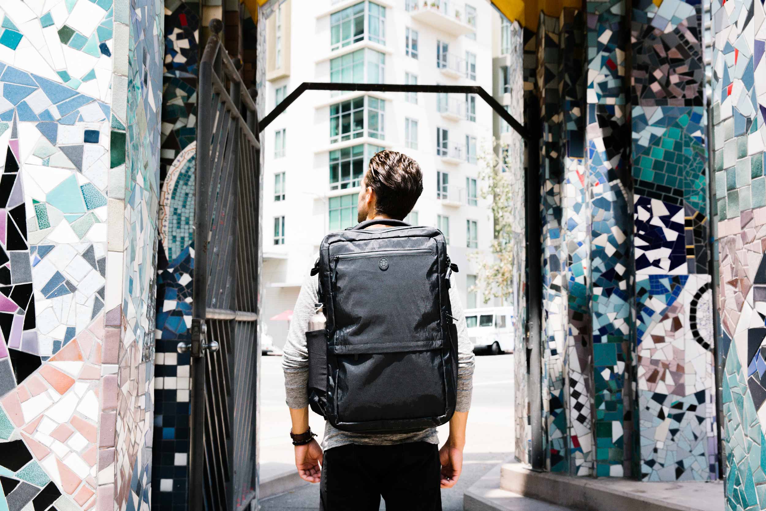 Man standing next to colorful mosaic