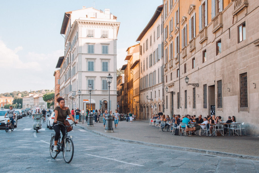 Woman bicycling through streets of Italy