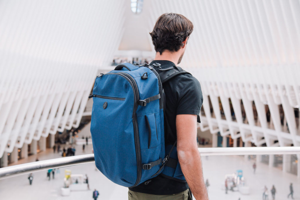 Man wearing a blue backpack at an airport