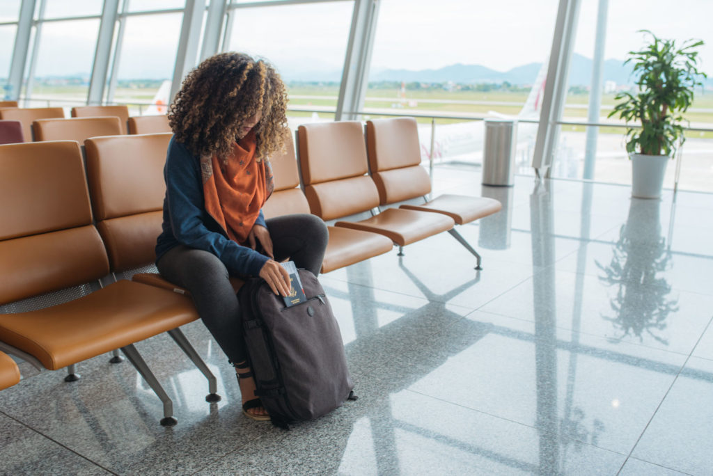 Woman packing a personal item backpack at the airport