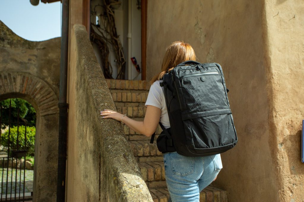 Woman wearing a travel backpack walking up stairs
