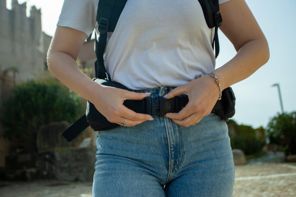 Buckling the hip belt on a travel backpack