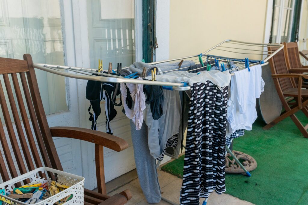 Hanging clothes to dry on a drying rack on an apartment balcony