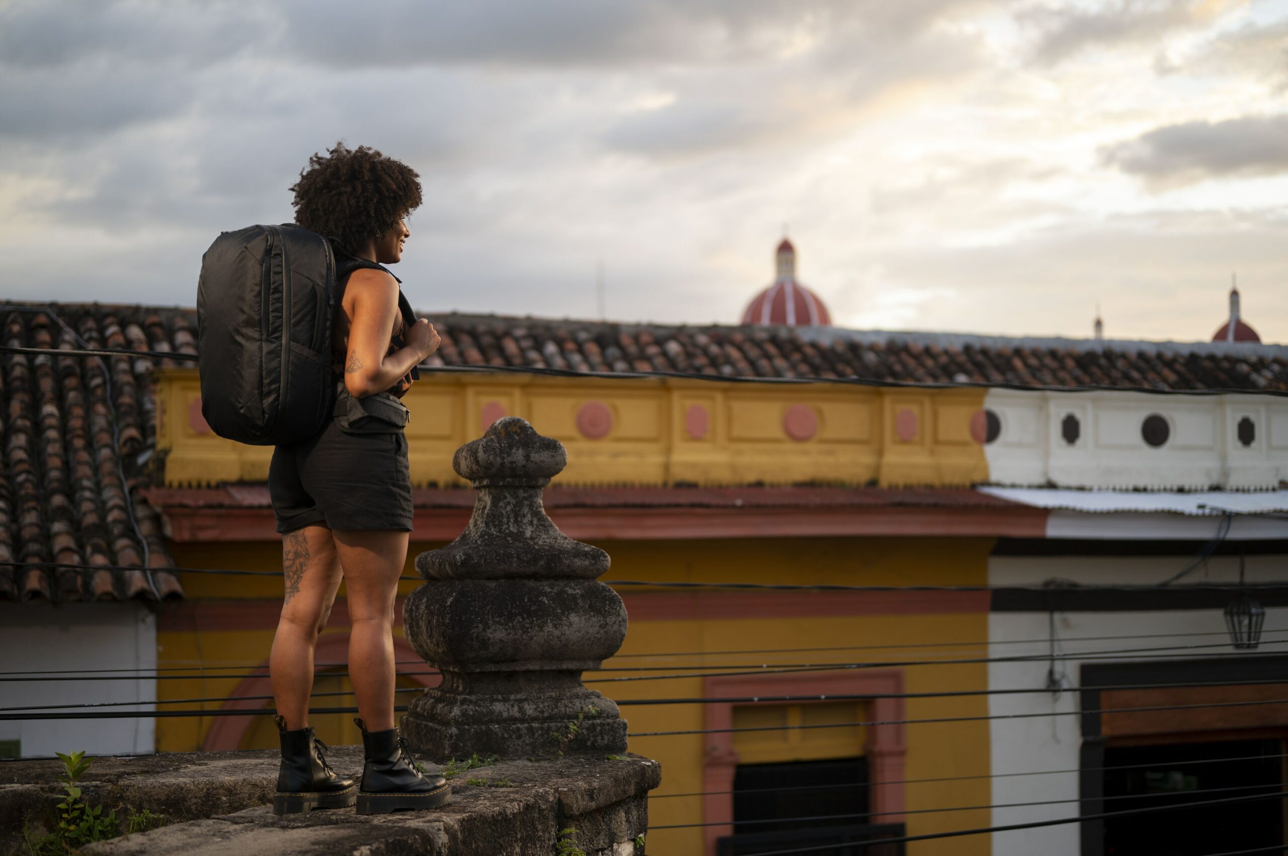 Woman wearing a backpack looking out over roofs